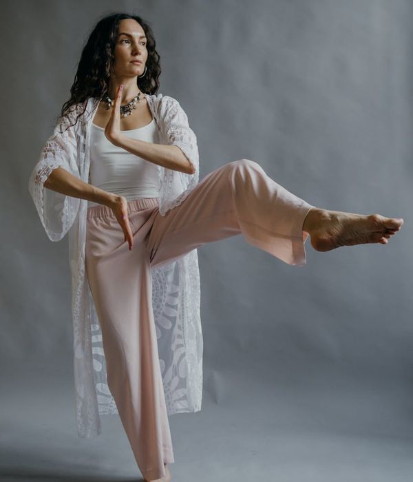 Person practicing gentle mobility movements in a dark studio
